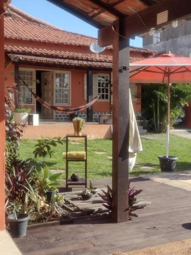 uma cadeira em frente a uma casa em Guest House Flor de Laranjeira em São Pedro da Aldeia