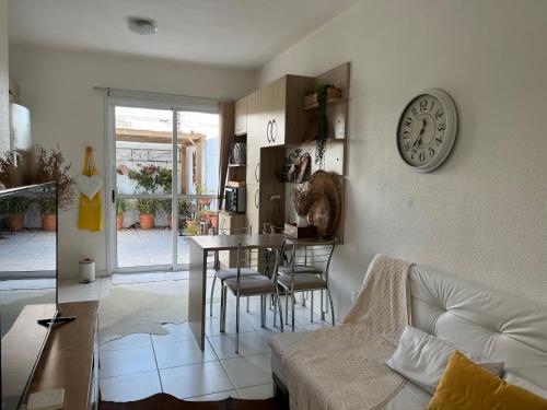 Una sala de estar con una mesa y un reloj en la pared. en Casatempo Moradas Pelotas Quartier proximo hospital Unimed, en Pelotas
