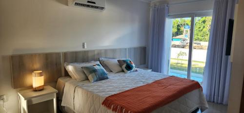 1 dormitorio con 1 cama y ventana grande en Casa em condominio em Arraial d'Ajuda, en Porto Seguro