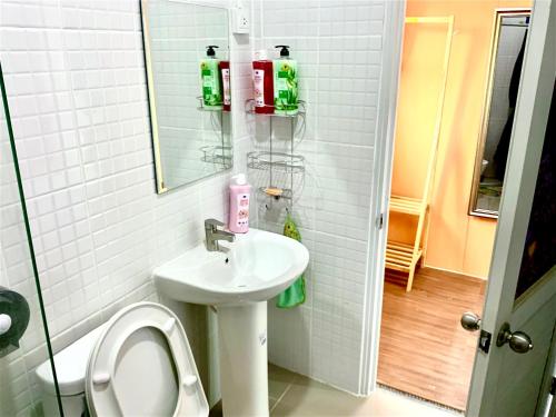 ein Badezimmer mit Waschbecken, Toilette und Spiegel in der Unterkunft Ban Ing Suan in Samutprakarn