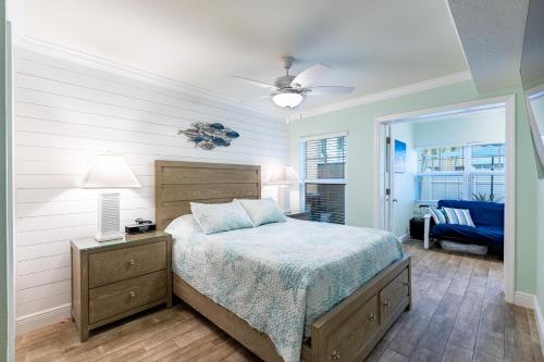 ein Schlafzimmer mit einem Bett, einer Lampe und einem Stuhl in der Unterkunft Gorgeous Coastal Condo Barefoot Beach Indian Shore in Clearwater Beach