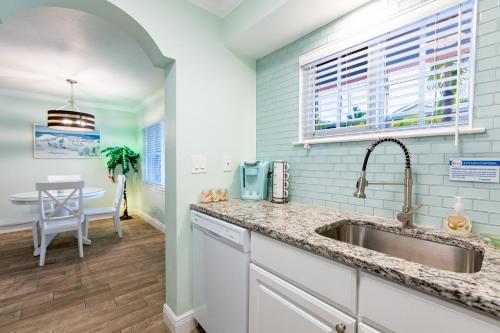 a kitchen with a sink and a table at Gorgeous Coastal Condo Barefoot Beach Indian Shore in Clearwater Beach