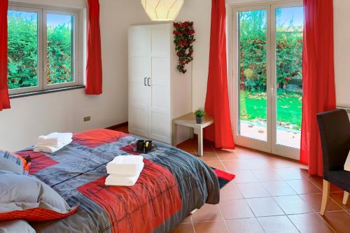 a bedroom with a bed with red curtains at PrimeStay in Nicolosi