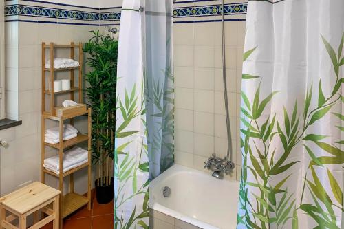 een badkamer met een bad en een douchegordijn met planten bij PrimeStay in Nicolosi