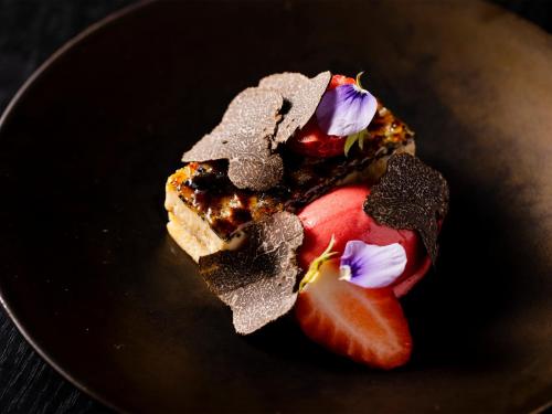 a black plate with a piece of dessert on it at Twin-Line Hotel Karuizawa Japan in Karuizawa
