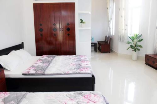 1 dormitorio con 2 camas y puerta de madera en Sea Stars Hotel, en Rạch Giá