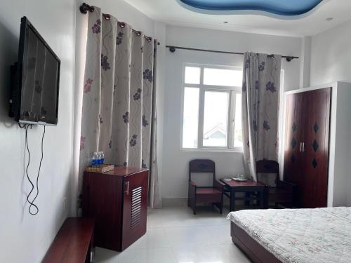 1 dormitorio con 1 cama, TV y ventana en Sea Stars Hotel, en Rạch Giá