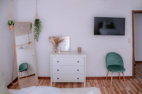 海格爾的住宿－Motel Kalos，一间卧室配有白色梳妆台和两把椅子