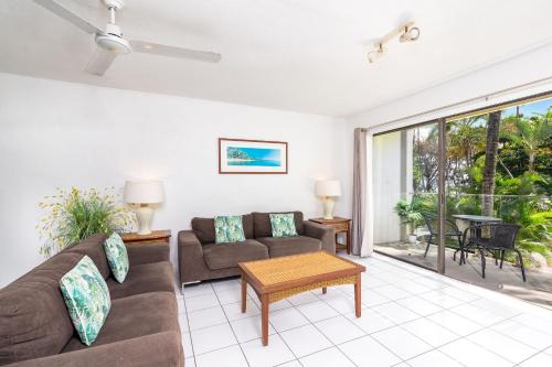 a living room with a couch and a table at Seascape Holidays at Beachfront Terraces in Port Douglas
