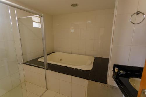 a bathroom with a bath tub and a sink at Atrium Express Hotels in Parauapebas