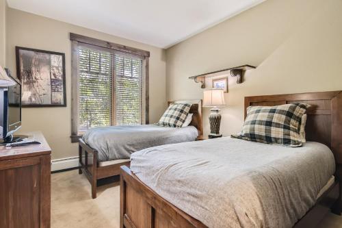 1 dormitorio con 2 camas, TV y ventana en Cozy 2BR Breck Getaway Peaceful Balcony View en Breckenridge