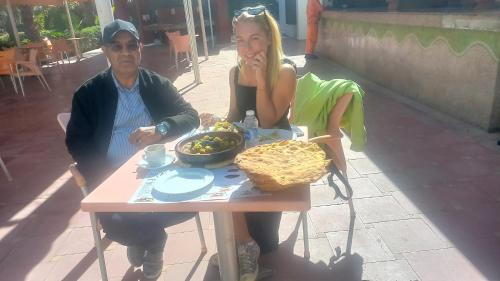 a man and a woman sitting at a table with food at Airport Agadir Guest House in Agadir