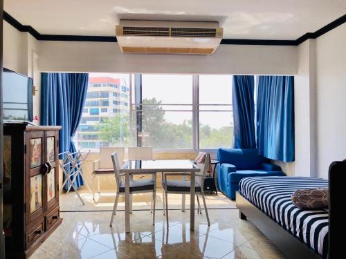 a living room with a dining room table and a bedroom at Jomtien Hill Resort Pratamnak in Pattaya South