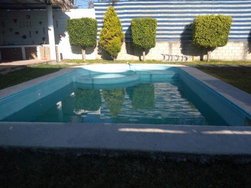 uma piscina de água com árvores e uma casa em Yatzil em La Trinitaria