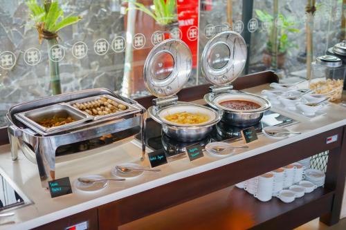 a buffet with bowls of food on a table at Swiss-Belinn Saripetojo Solo in Solo
