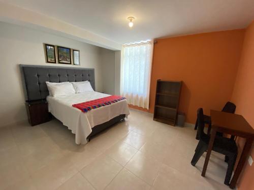 a bedroom with a bed and a table and a desk at Lonko Hostel Arequipa in Arequipa