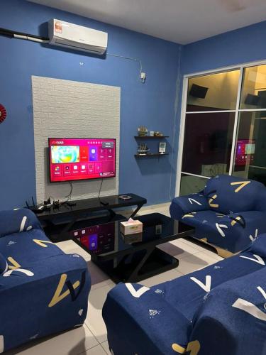 a blue living room with couches and a tv at FR Comfort SEAView Kuah, Langkawi in Kuah