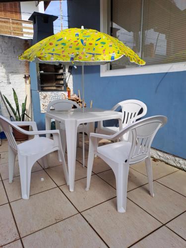 a white table with chairs and an umbrella at Paraíso do Ribeirao da Ilha in Florianópolis