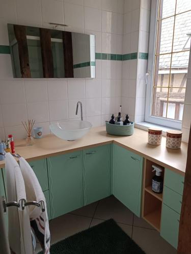 une salle de bain avec un lavabo et un miroir dans l'établissement Le logis de la rue des Arts, à Blois