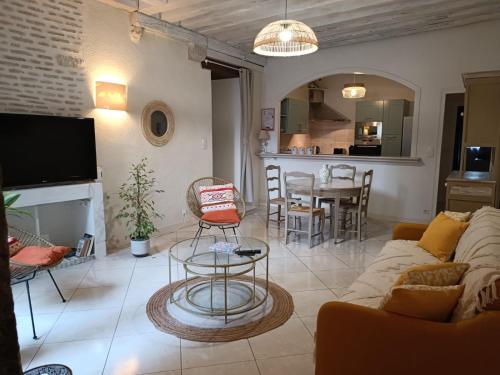 - un salon avec un canapé et une table avec des chaises dans l'établissement Le logis de la rue des Arts, à Blois