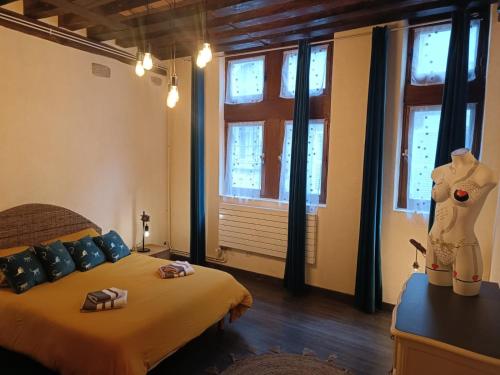 - une chambre avec un lit et 2 cadeaux dans l'établissement Le logis de la rue des Arts, à Blois
