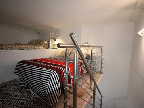 Cette petite chambre comprend des lits superposés et une étagère. dans l'établissement T2 bis rénové à Arcachon centre avec 2 terrasses, clim, parking, proche plage et gare. - FR-1-420-84, à Arcachon