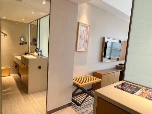 a bathroom with a sink and a vanity with a mirror at Guangzhou Nanhong Ausotel Hotel in Guangzhou