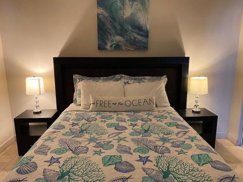 a bed with a comforter and two nightstands at Playa Bonita Rosarito in Rosarito