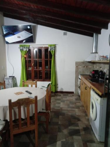 cocina con mesa y cocina con cortinas verdes en Yireh en Esquel