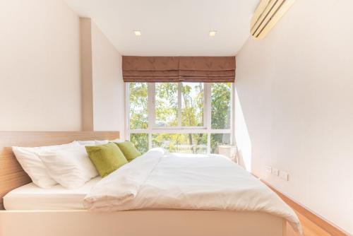 Ce lit se trouve dans un dortoir doté d'une grande fenêtre. dans l'établissement Lovely room next to BKK airport, food marts, quiet place to stay, à Bangkok