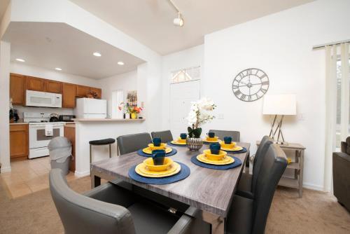 a dining room and kitchen with a table and chairs at Pet Friendly House in Resort Style Condo Near Disney, 4 Pools, Hot Tub & Gym in Kissimmee