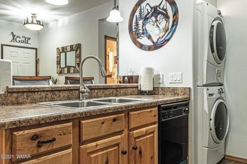 a kitchen with a sink and a refrigerator at Casita at Bison Ridge in Show Low