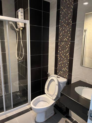 La salle de bains est pourvue de toilettes, d'une douche et d'un lavabo. dans l'établissement Grand Lopburi, à Lop Buri