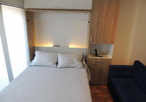 1 dormitorio pequeño con 1 cama y 1 sofá azul en MONOAMBIENTE VISTA AL RIO, en Florida