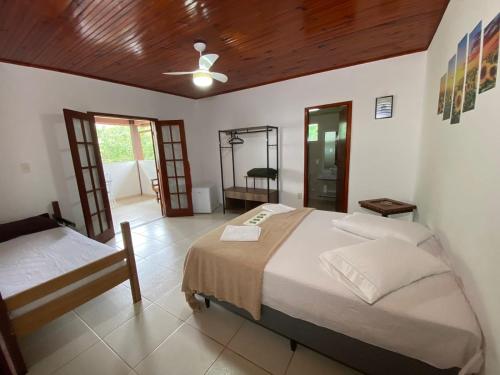 um quarto com 2 camas e uma ventoinha de tecto em GREENHOUSE Hospedagem em Macaé