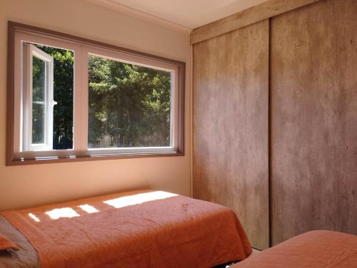 sypialnia z łóżkiem i oknem w obiekcie Entre Ruta 5 Sur y Villarrica w mieście Villarrica