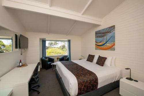 a bedroom with a bed and a desk with a computer at Mercure Kangaroo Island Lodge in American River