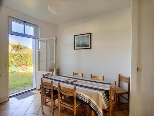une salle à manger avec une table et des chaises et une fenêtre dans l'établissement Maison de Caractère avec Jardin, à 300m de la Plage et Commerces - FR-1-361-60, à Jullouville