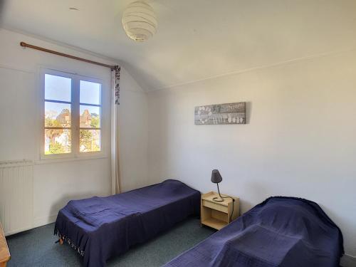deux lits dans une chambre avec une fenêtre dans l'établissement Maison de Caractère avec Jardin, à 300m de la Plage et Commerces - FR-1-361-60, à Jullouville
