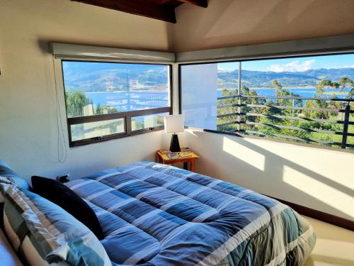a bedroom with a bed in front of a large window at Sky Club - Apartamento Completo in Guatavita