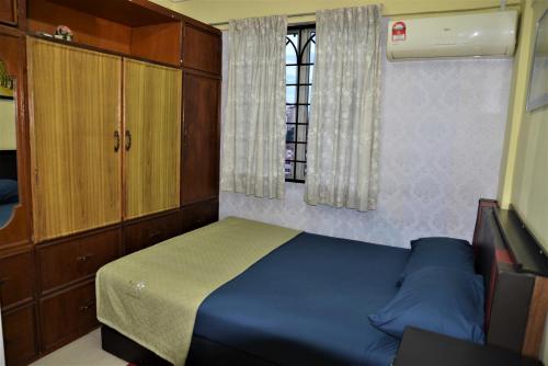 a small bedroom with a blue bed and a window at Awedee Homestay Putrajaya in Putrajaya