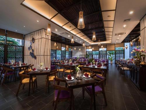 河內的住宿－Muse Hanoi PentStudio West Lake，餐厅设有木桌、椅子和窗户。
