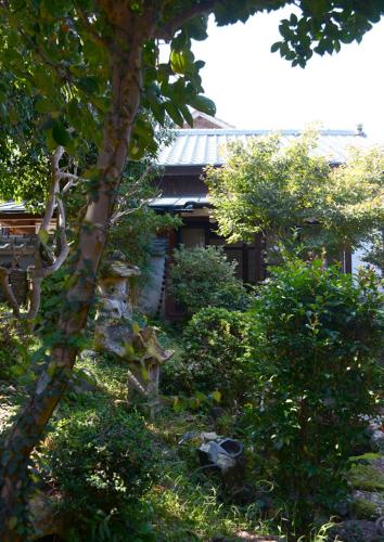 a garden with a stone statue in front of a house at 続異人館 ZOKU IJINKAN Guest House in Arita