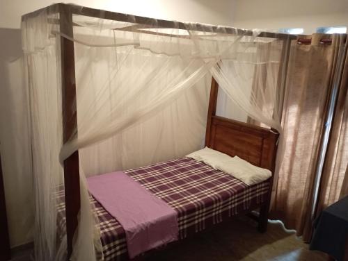 a small bed with a canopy in a room at Surf Forever in Midigama