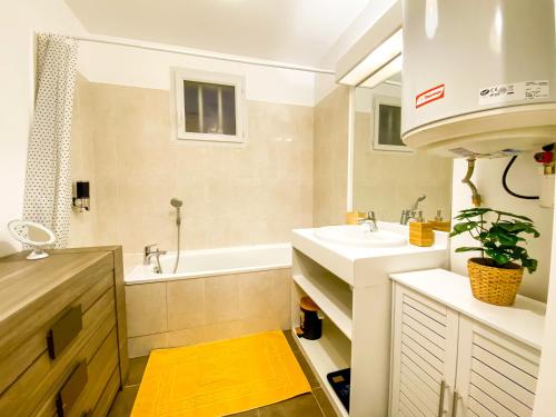 La salle de bains est pourvue d'un lavabo et d'une baignoire. dans l'établissement The Golden House * Parking * Garden, à Corbeil-Essonnes