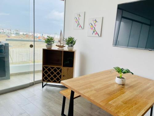 a dining room with a wooden table and a window at A 3 minutos de la Playa Hermoso Departamento con Piscina y Parrilla in Asia