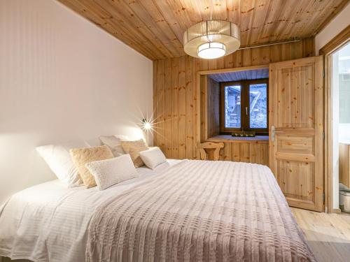 une chambre avec un grand lit dans une pièce aux murs en bois dans l'établissement Élégant appartement rénové avec wifi au cœur du vieux Val-d'Isère, proche des pistes et commodités - FR-1-694-313, à Val dʼIsère