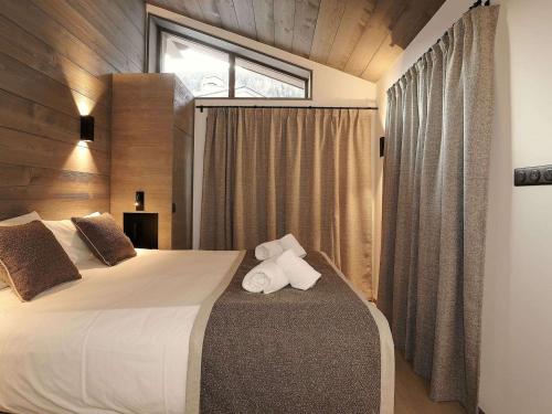 une chambre avec un lit avec deux serviettes dessus dans l'établissement Appartement moderne à Courchevel Le Praz, proche des pistes avec parking et wifi - FR-1-568-31, à Courchevel