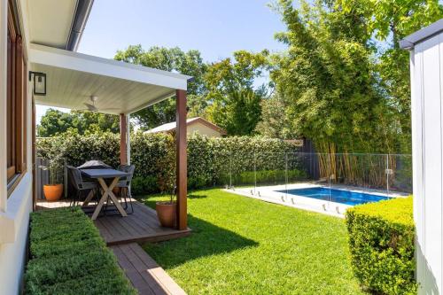 a backyard with a table and a swimming pool at The Cottage on Market in Mudgee