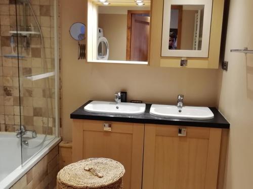 une salle de bain avec deux lavabos et une douche dans l'établissement Spacieux 4P avec balcon sud, cheminée et parking, proche funiculaire et centre de Bourg-Saint-Maurice - FR-1-411-876, à Bourg-Saint-Maurice
